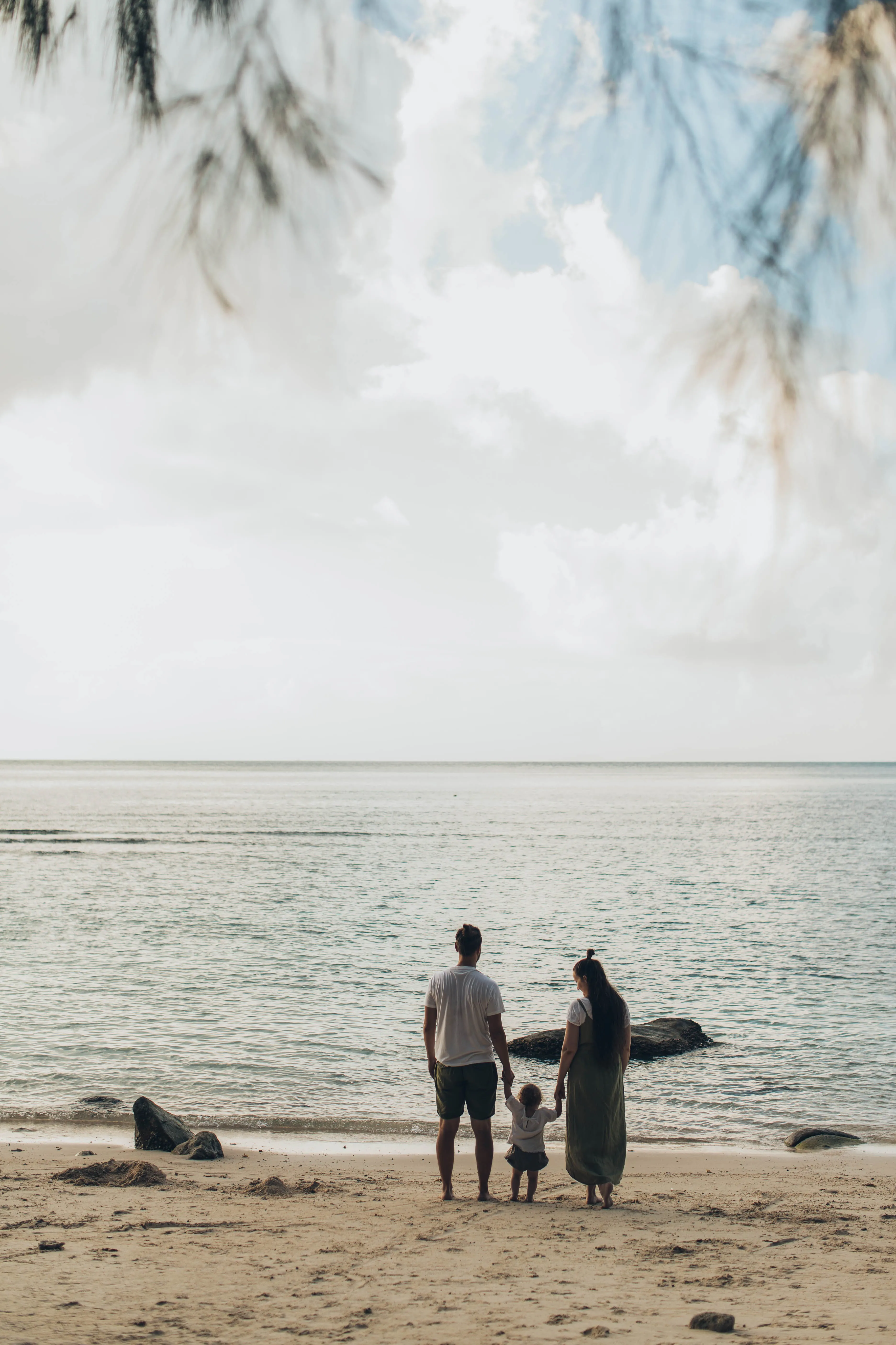 A family on the beach looking out onto the ocean